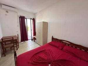 a bedroom with a bed with a red blanket at Sar Hotel, Velipojë in Velipojë +2 photos