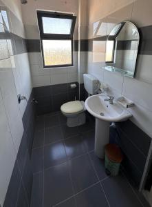a bathroom with a toilet and a sink and a mirror at Sar Hotel, Velipojë in Velipojë