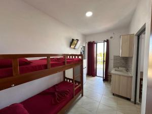 a bedroom with two bunk beds and a bathroom at Sar Hotel, Velipojë in Velipojë