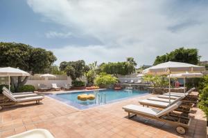 ein Swimmingpool mit Liegestühlen und Sonnenschirmen in der Unterkunft The Cookbook Hotel & SPA in Calpe