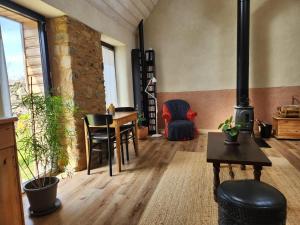 a living room with a wood stove and a table at Ti an Avel, petite maison indépendante avec jardin à 5 minutes à pied de la mer in Plougrescant