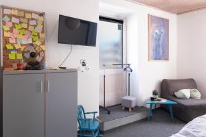 a room with a bed and a chair and a television at Studio apartment LoSt in Ogulin