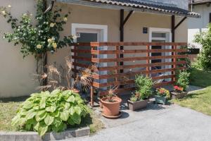 a fence in front of a house with potted plants at Studio apartment LoSt in Ogulin