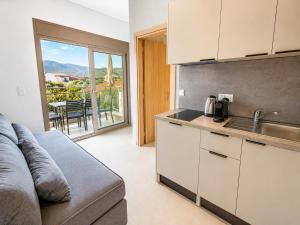 a kitchen with a couch and a table with a view at B Cozy Apartments in Limenaria