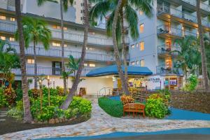 a hotel with palm trees in front of a building at Courtyard by Marriott Waikiki Beach in Honolulu