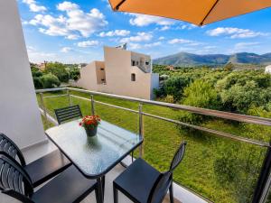 a table and chairs on a balcony with a view at B Cozy Apartments in Limenaria