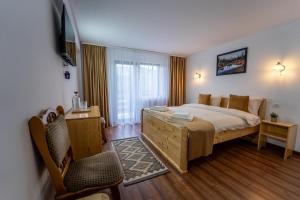 a bedroom with a large bed and a chair at Belvedere Retezat in Cîmpu lui Neag
