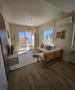 a living room with a couch and a large window at Riviera Feeling - Ospedaletti in Ospedaletti