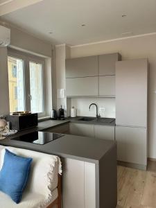 a kitchen with white cabinets and a blue pillow at Riviera Feeling - Ospedaletti in Ospedaletti +18 photos