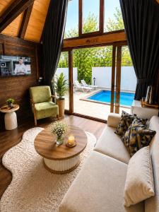 a living room with a couch and a table and a pool at Oce Bungalow in Ardeşen