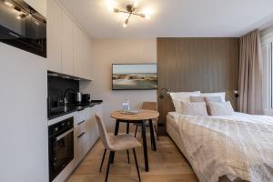 a bedroom with a bed and a table and a kitchen at Appartement Agnes in Westerland