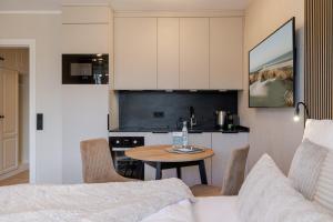 a living room with a table and a kitchen at Appartement Agnes in Westerland