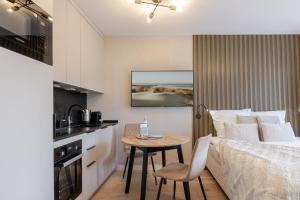 a bedroom with a bed and a table and a kitchen at Appartement Agnes in Westerland +25 photos