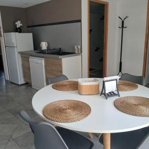 a white table and chairs in a kitchen at Gîte LA FONTAINE DU MARAIS in Pendé