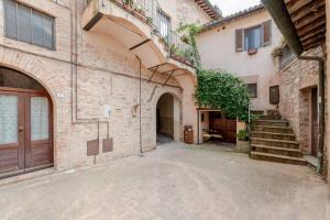 an empty alley with a building with a door and stairs at Gabri's Home in Spello