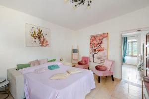 a bedroom with a white bed and pink chairs at Gabri's Home in Spello