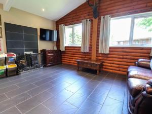 a living room with wood paneling and a couch and windows at The Red in St Asaph