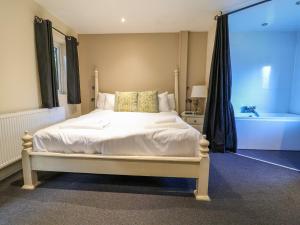 a bedroom with a bed and a bath tub and a tub at The Red in St Asaph