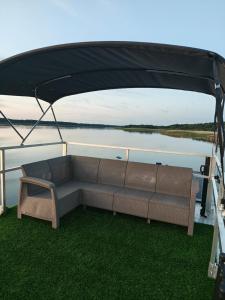 a couch sitting under a gazebo on a boat at Mazurska Osada Just in Łupki