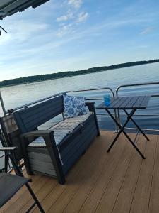 a bench and a table on the deck of a boat at Mazurska Osada Just in Łupki +5 photos