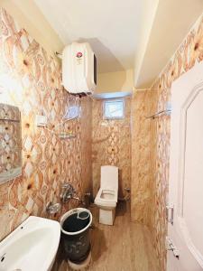 a bathroom with a toilet and a sink at Regency Shooryaa Near The Mall Shimla in Shimla