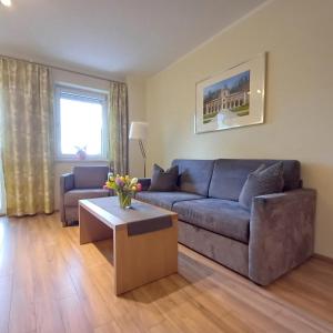 a living room with a blue couch and a coffee table at Hölbinger Alm - Apartments in Anger +234 photos
