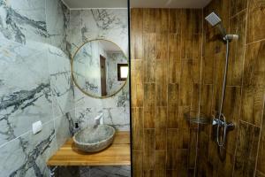 a bathroom with a stone sink and a mirror at Belvedere Retezat in Cîmpu lui Neag