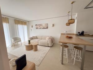 eine Küche und ein Wohnzimmer mit Sofa und Tisch in der Unterkunft EASY Tropez in Grimaud