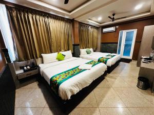 a bedroom with two beds and a window at Satkar Comforts in Attigundi