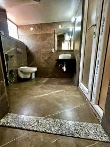 a bathroom with a toilet and a sink at Satkar Comforts in Attigundi