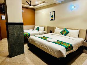 a hotel room with two beds in a room at Satkar Comforts in Attigundi