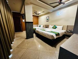 a hotel room with two beds in a room at Satkar Comforts in Attigundi +16 photos