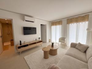 ein Wohnzimmer mit Sofa und Fernseher in der Unterkunft EASY Tropez in Grimaud