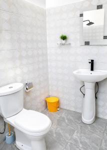 a bathroom with a white toilet and a sink at Tumaini Bungalows in Nungwi