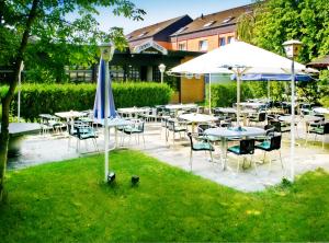 a patio with tables and chairs and umbrellas at Hotel Pfälzer Hof GmbH in Braunschweig