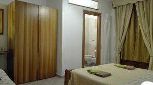 ein Schlafzimmer mit 2 Betten und ein Badezimmer mit einem WC in der Unterkunft Alfieri Bed & Breakfast in Pisa