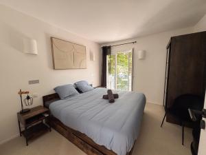 ein Schlafzimmer mit einem großen Bett, auf dem ein Teddybär liegt in der Unterkunft EASY Tropez in Grimaud