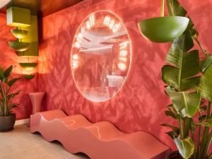 a room with a pink wall with a mirror at Ibis Styles Madrid Airport Valdebebas in Madrid