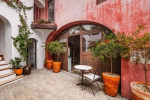 a table and chairs in front of a building with potted plants at Quarto Duplo - Pacote Alentejo 3 Noites in Alcáçovas