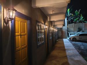 a hallway of a building with a door and a car at Felício Reis - Pousada Colonial in Conceição do Mato Dentro