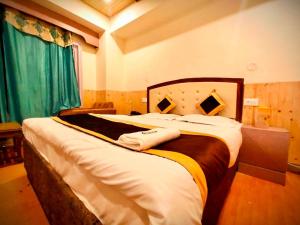 a bedroom with a large bed with two towels on it at Regency Shooryaa Near The Mall Shimla in Shimla +30 photos