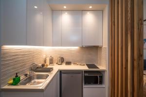 a kitchen with a sink and a counter top at Perla Port Suites in Chios