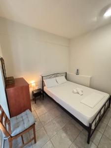 a small bedroom with a bed and a chair at Stergios Apartment Evdilos Ikaria in Evdilos
