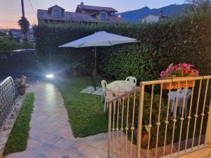 a patio with an umbrella and a table and chairs at CasaMiria in Seravezza
