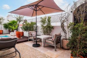 a patio with an umbrella and chairs and a table at Quarto Duplo - Pacote Alentejo 3 Noites in Alcáçovas +33 photos