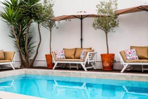 a swimming pool with chairs and an umbrella next to a pool at Quarto Duplo - Pacote Alentejo 3 Noites in Alcáçovas