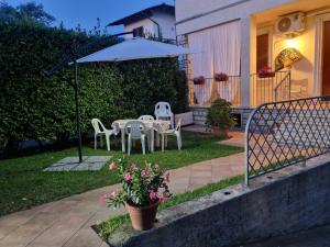 a patio with a table and chairs and an umbrella at CasaMiria in Seravezza