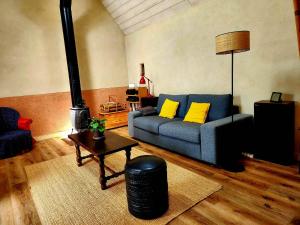 a living room with a blue couch and yellow pillows at Ti an Avel, petite maison indépendante avec jardin à 5 minutes à pied de la mer in Plougrescant +15 photos