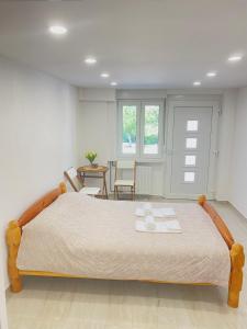 a bedroom with a large bed with two towels on it at Dora Apartman in Tomislavgrad
