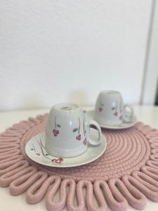 two tea cups and saucers sitting on a table at Dora Apartman in Tomislavgrad